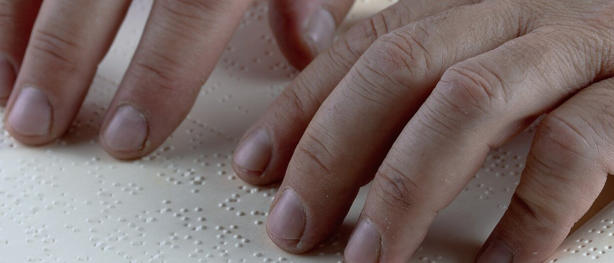 Picture of fingers on a Braille book