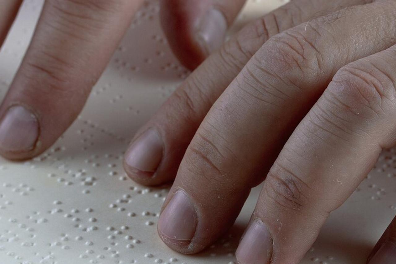 Picture of fingers on a Braille book